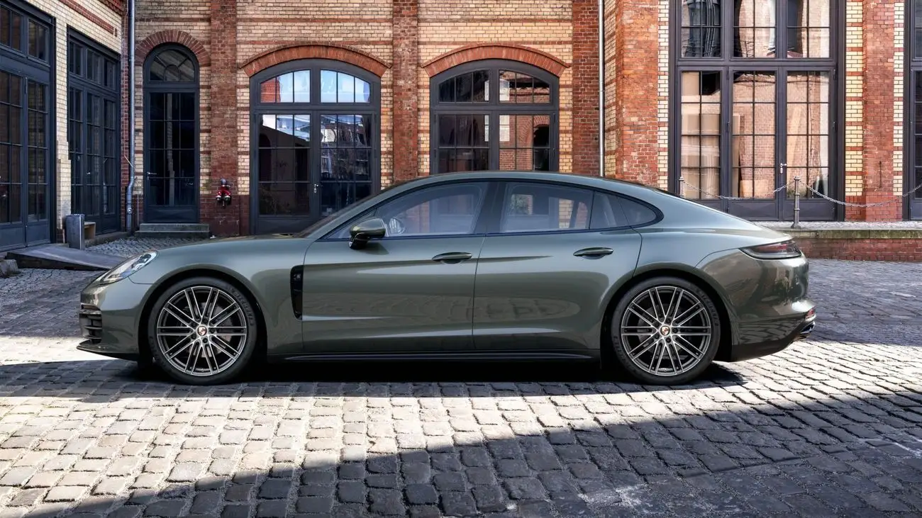 Dark green Porsche Panamera in front of a brick building